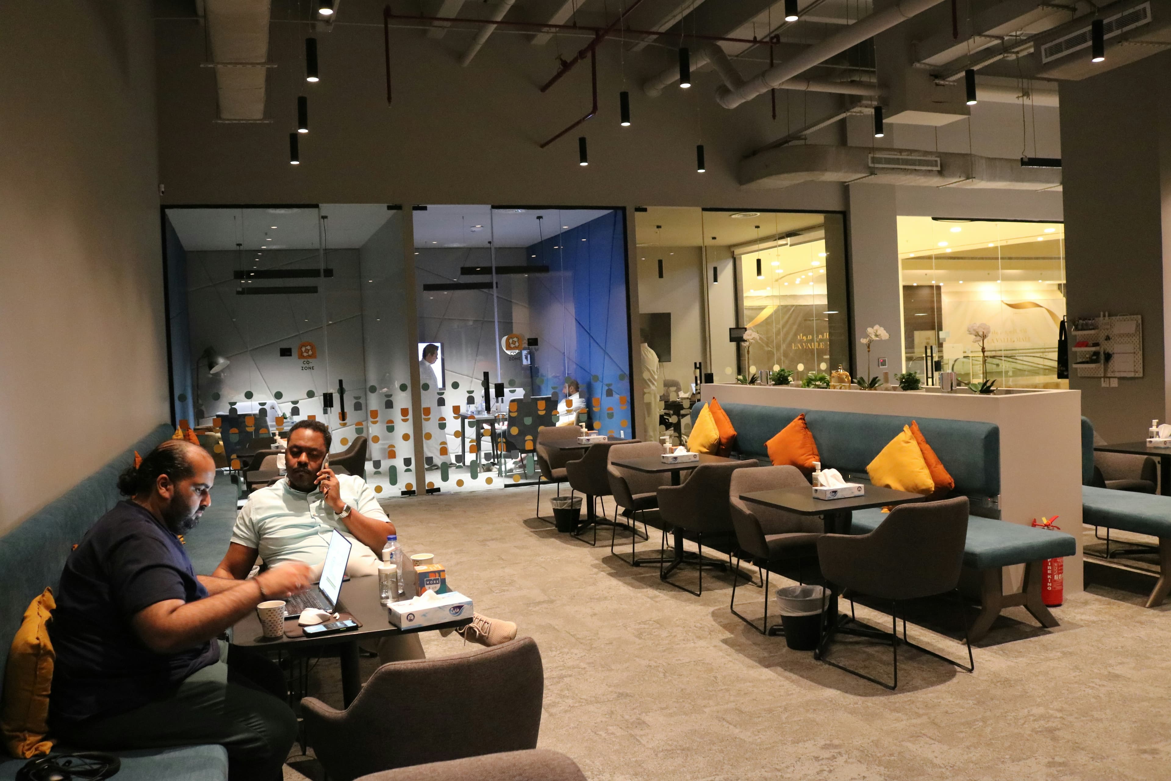 A team working from laptops in an open office lounge